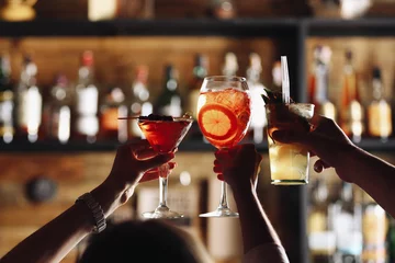 Keuken foto achterwand Cocktail Vrienden roosteren met cocktails in bar