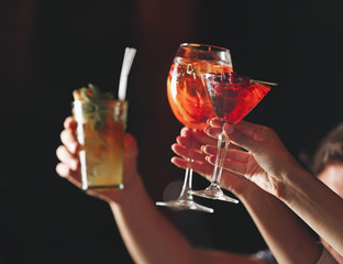 Friends toasting with cocktails in bar