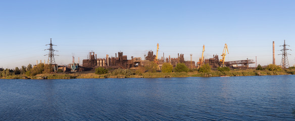 Picture of metallurgical plant and its Smoking chimneys in the background of clear sky