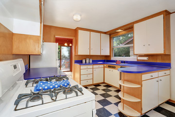 Classic kitchen room interior with white cabinets with blue counter top.