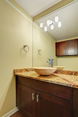 Fototapeta na wymiar Adorable vanity cabinet with marble vessel sink and large mirror in the bathroom