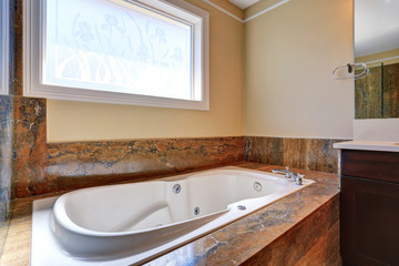 Luxury bathroom interior with white bath tub with marble trim