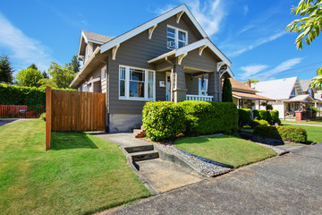 Classic American house exterior with siding trim and well kept garden.