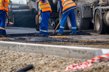 The workers and the asphalting machines