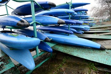 Colorful Kayaks and canoes in a Row stack