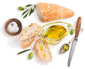 Olive oil and slices of baguette, above view.