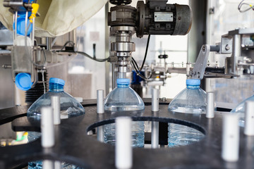 Water factory - Water bottling line for placing the cap on the bottles. 