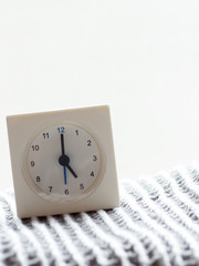 Series of a simple white analog clock on the blanket, 1/15