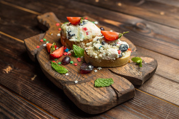bruschetta with cottage cheese on wooden board