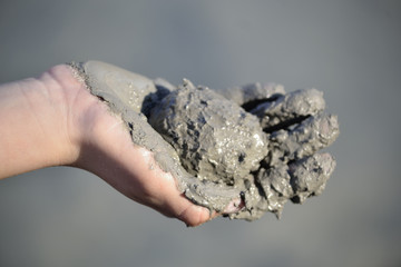 Mano de ni&ntilde;o con bola de barro.