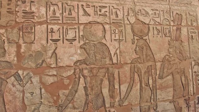 Ancient Egyptian hieroglyphic carvings on a temple wall at Medinat Habu in Luxor Egypt