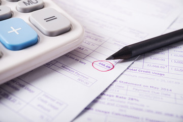 Utility bill with calculator and pencil