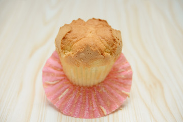 homemade cup cake with the outer opened on a wood background