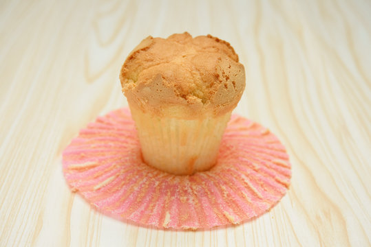 homemade cup cake with the outer opened on a wood background