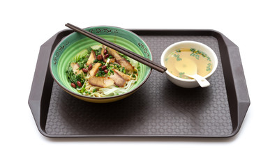 guilin rice noodles with bowl of soup nearby on a plastic plate on white