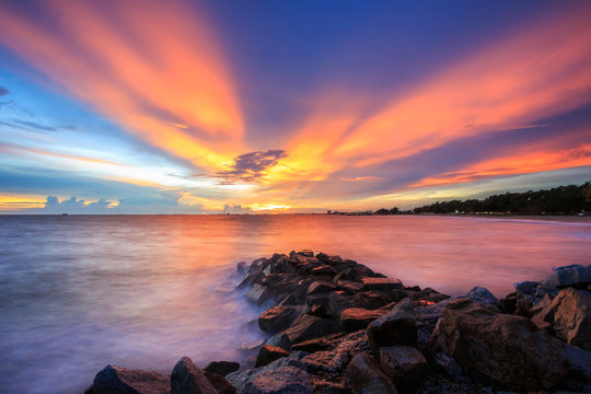 Rock Coastal sunset seascape with sunburst. This image was taken in Royong Thailand