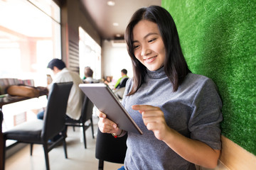 Woman typing tablet in cafe