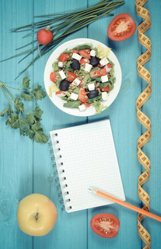 Vintage photo, Greek salad with vegetables, centimeter and notepad for notes, healthy food and slimming concept
