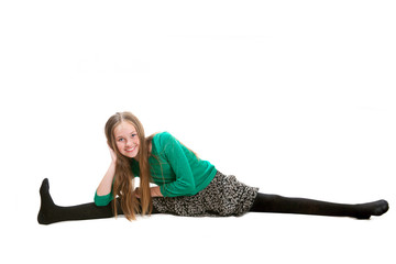 An eleven years old girl is making leg-split exercise
