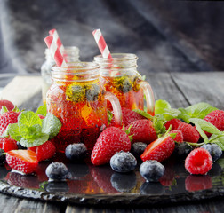 berry juice in a glass with berries, ice and mint