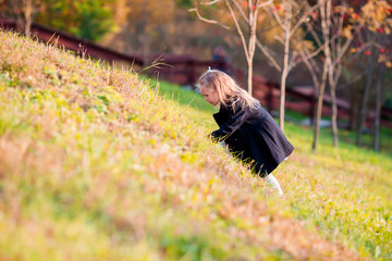 Adorable little girl outdoors at beautiful autumn day