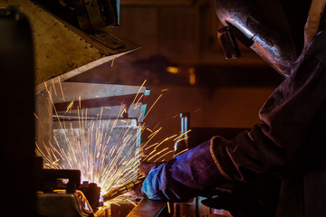 Worker welding automotive part i8n factory