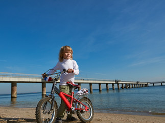 boy with bicycle on sea