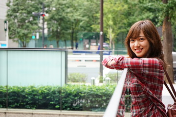 Young Japanese business woman relaxing outside her office