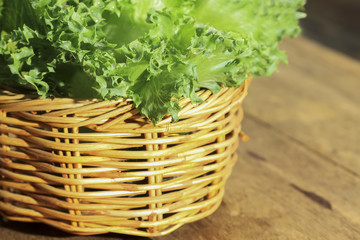 Fototapeta na wymiar Green vegetables in the basket on wooden table for background decoration.