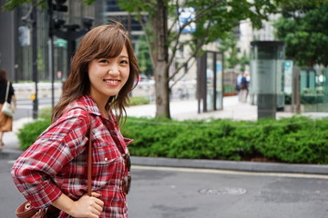 Fototapeta premium Young Asian woman pointing over there while traveling abroad