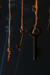 Fototapeta na wymiar Keys hanging on a string. Smoke background. Selective focus