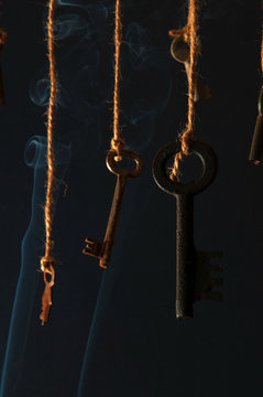 Keys hanging on a string. Smoke background. Selective focus