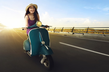 Fototapeta na wymiar Young asian women enjoy riding a scooter and having fun