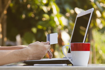 hands with credit card and laptop buying online