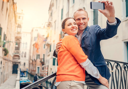 Loving couple take a selfie on the one of bridge over a channel