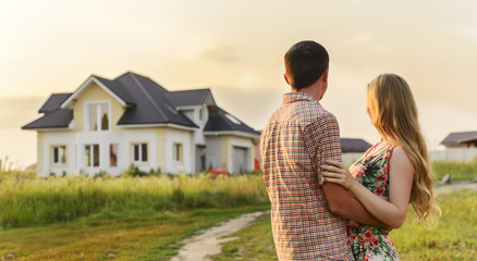 Young Couple Standing Outside Dream Home