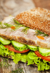Tasty rye bread sandwiches with roast meat and vegetables