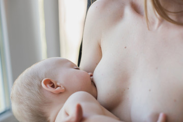 Close-up portrait mother breastfeeding her baby with breast milk