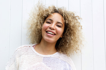 Fototapeta premium Smiling beautiful woman standing by wall
