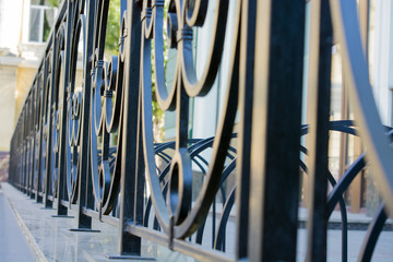 Black iron rod. Wrought fence. The pattern of bars