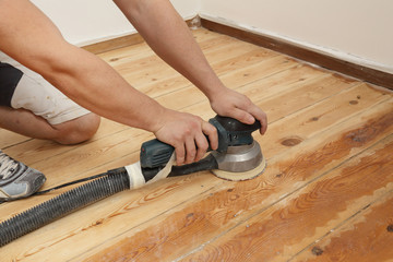 homme ponçant plancher