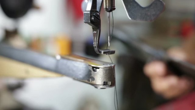 Calzolaio al Lavoro nella sua bottega artigianale. Preparazione filo macchina da cucire manuale.