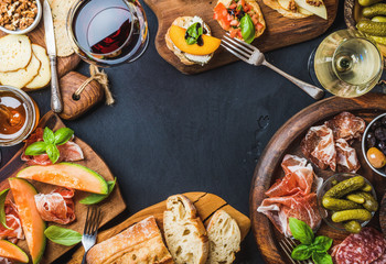 Italian antipasti wine snacks set. Brushettas, cheese variety, Mediterranean olives, pickles,...