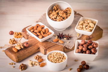 almonds, walnuts, hazelnuts cashews and pine nuts in wooden bowl