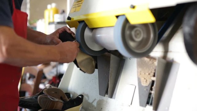 Calzolaio al Lavoro nella sua bottega artigianale. Smerigliatura scarpa da donna. 