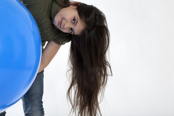 Junges, dunkelhaariges, Mädchen mit einem riesigen, blauen Ballon