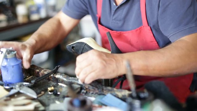 Calzolaio al Lavoro nella sua bottega artigianale.