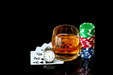 Cards with chips to poker and tumbler whiskey with clock