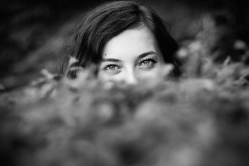 Monochrome glance from a woman behind the bushes