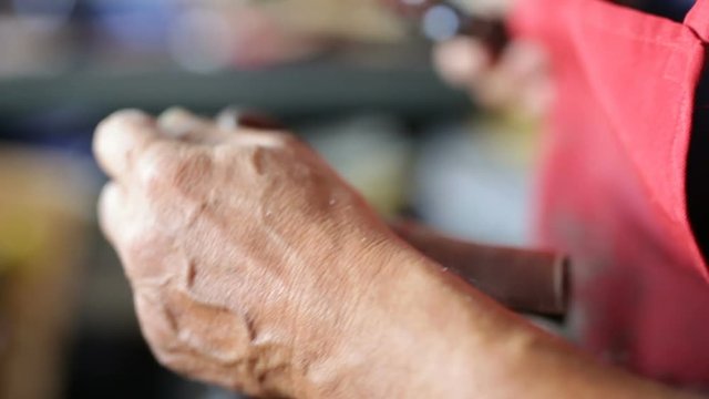 Calzolaio al Lavoro nella sua bottega artigianale. Riparazione Mocassino marrone uomo. 